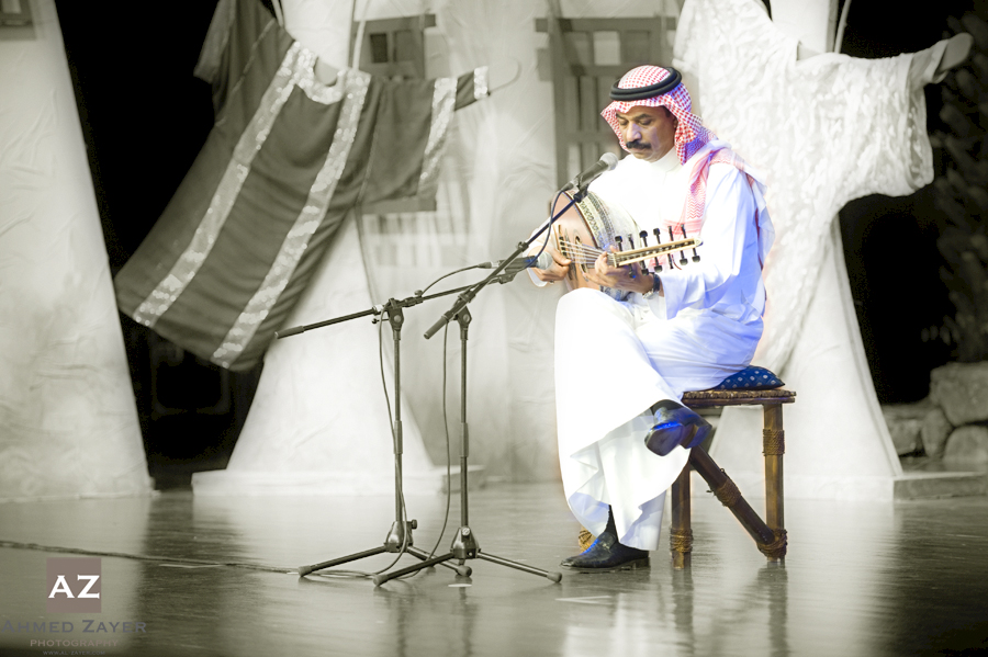 a man sitting on a chair holding an instrument