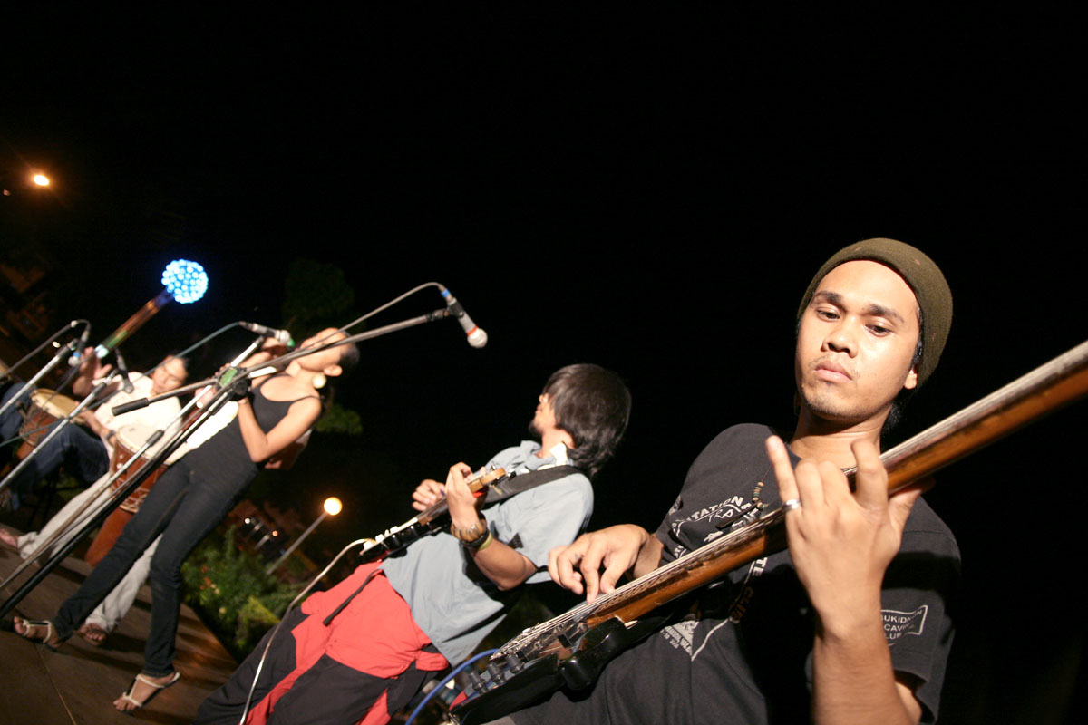 a man playing on a trombone next to a group of boys