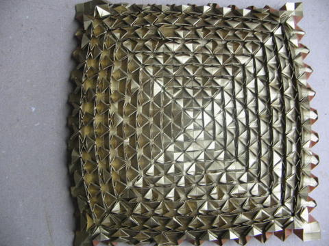 a shiny metal plate with metallic decorative shapes