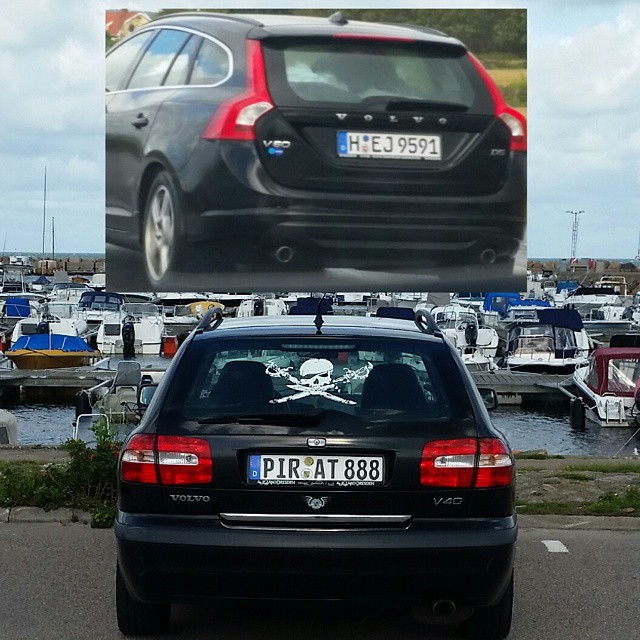a car parked in front of a billboard with boats in the background