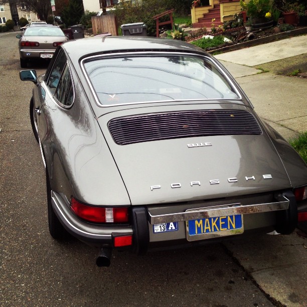 silver car parked on the curb near some houses