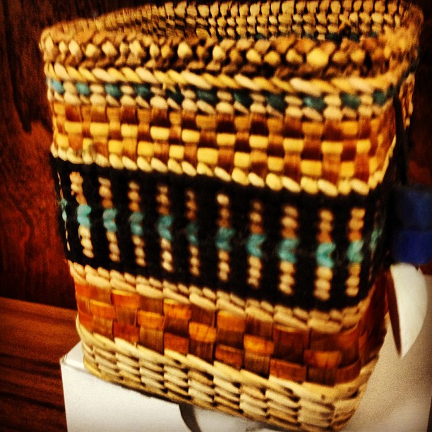 a long woven basket sitting on top of a toilet