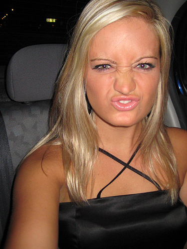 a blonde haired girl looks confused while sitting in the passenger seat