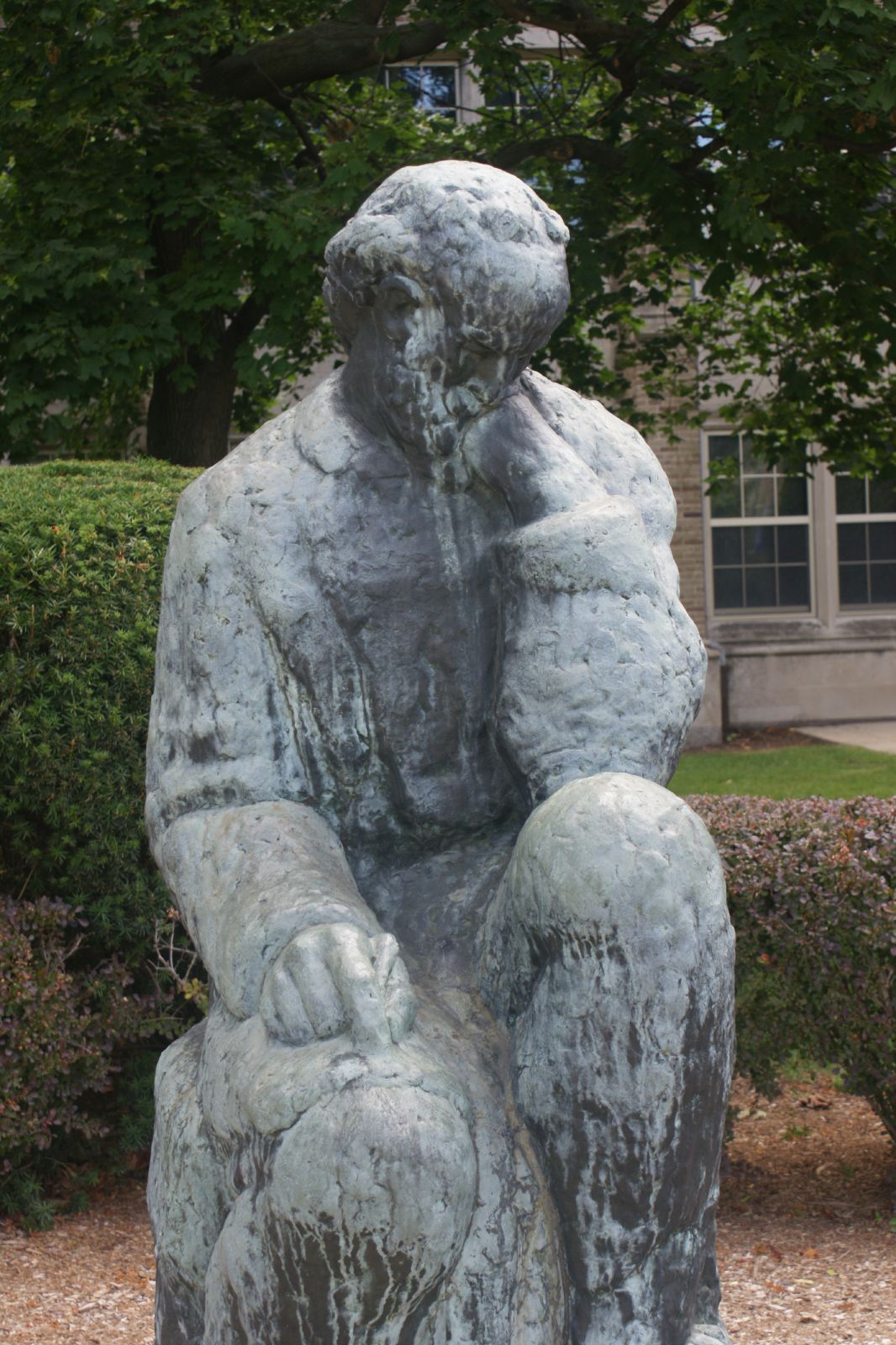 a statue of a man is sitting in a garden