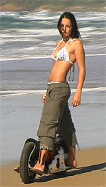 woman with long black hair in white bikini walking on beach
