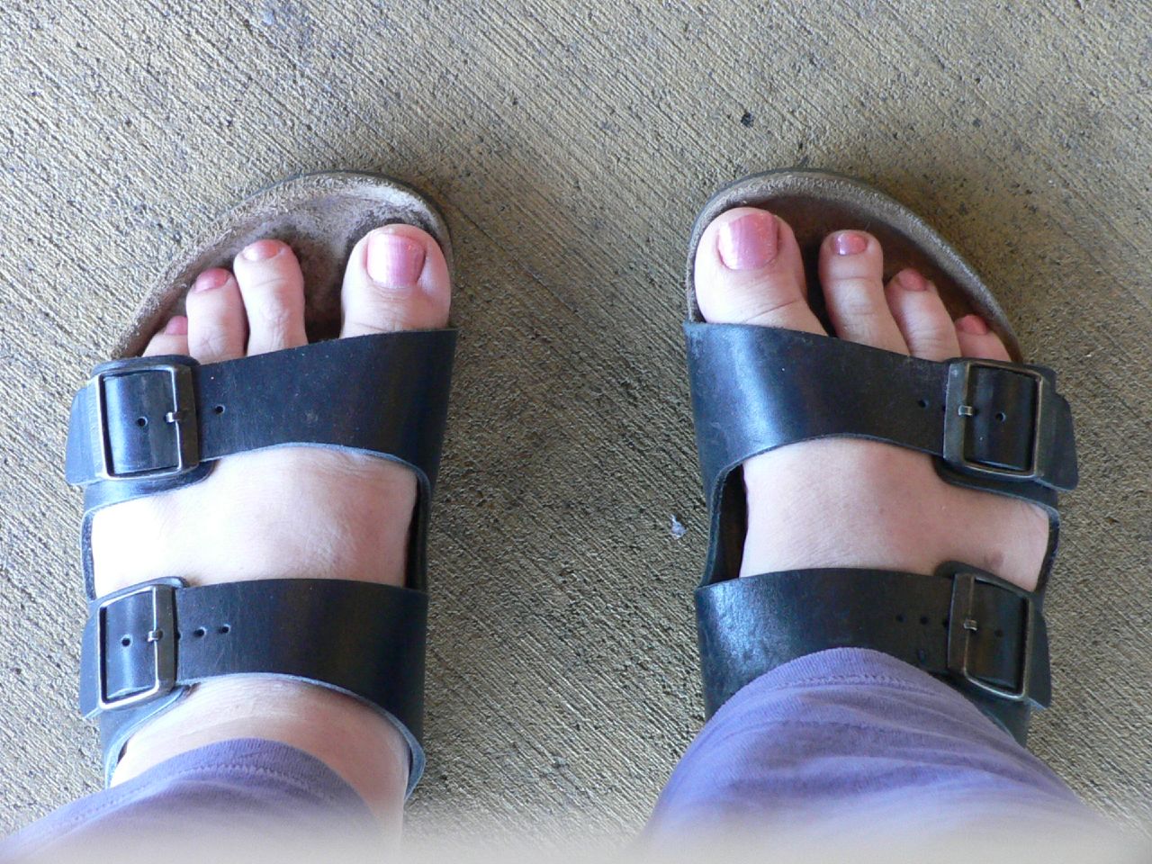 a close up of person wearing sandals and toe wraps