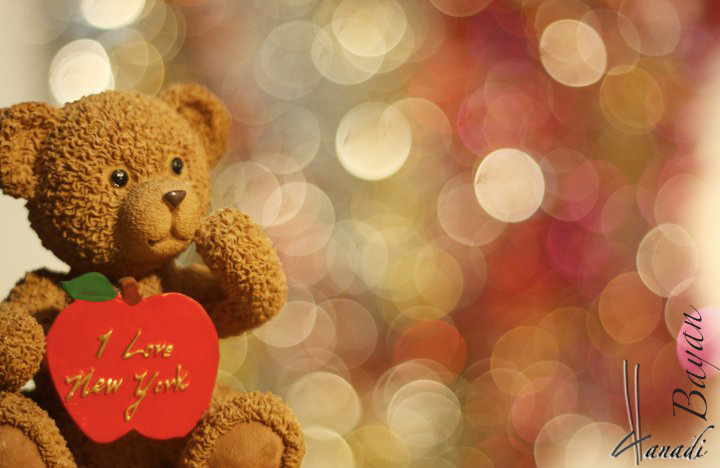 teddy bear holding a heart with a ribbon around it