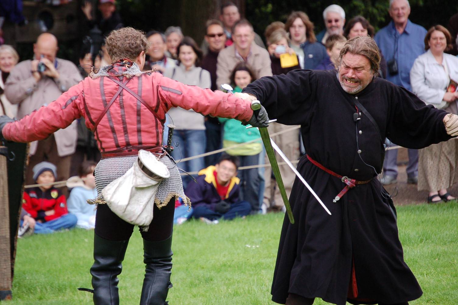 two men dressed in medieval costumes and holding swords