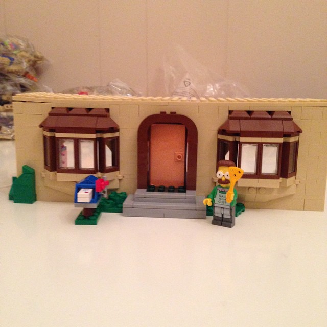 a lego simpsons house on display with a lego figure