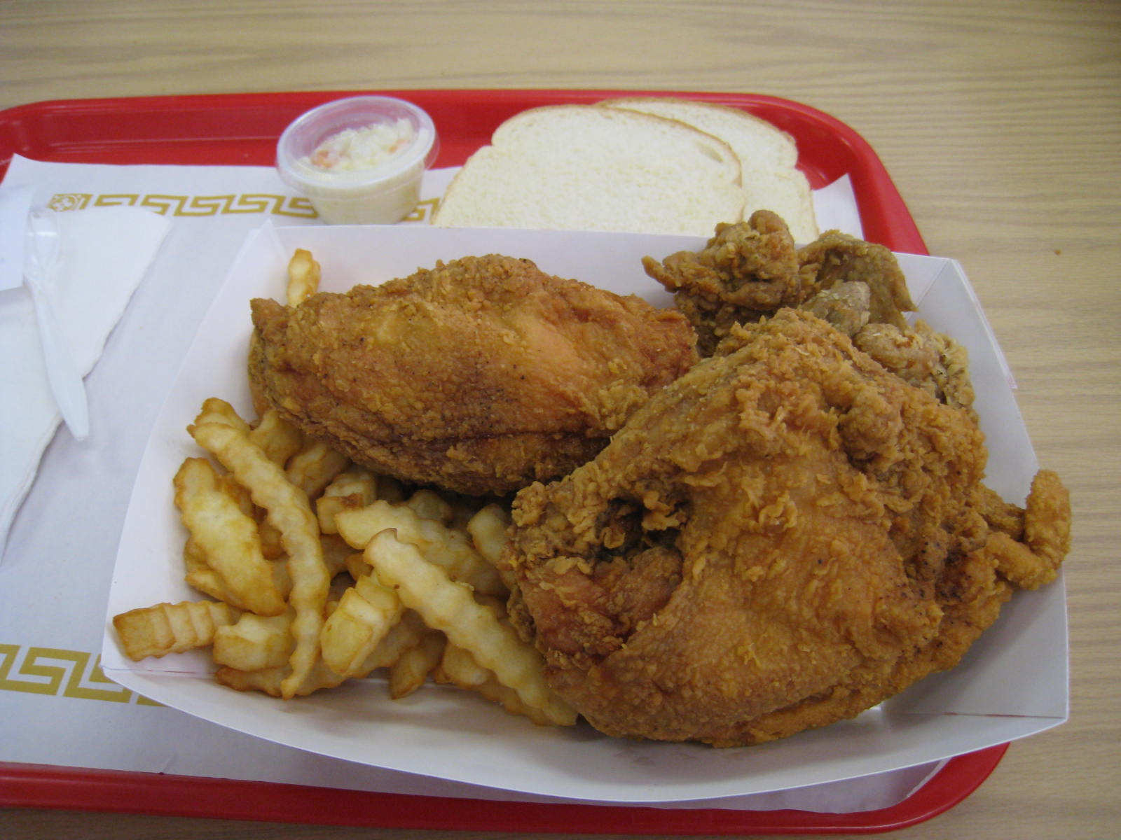 chicken, fries, and coleslaw are served on a tray