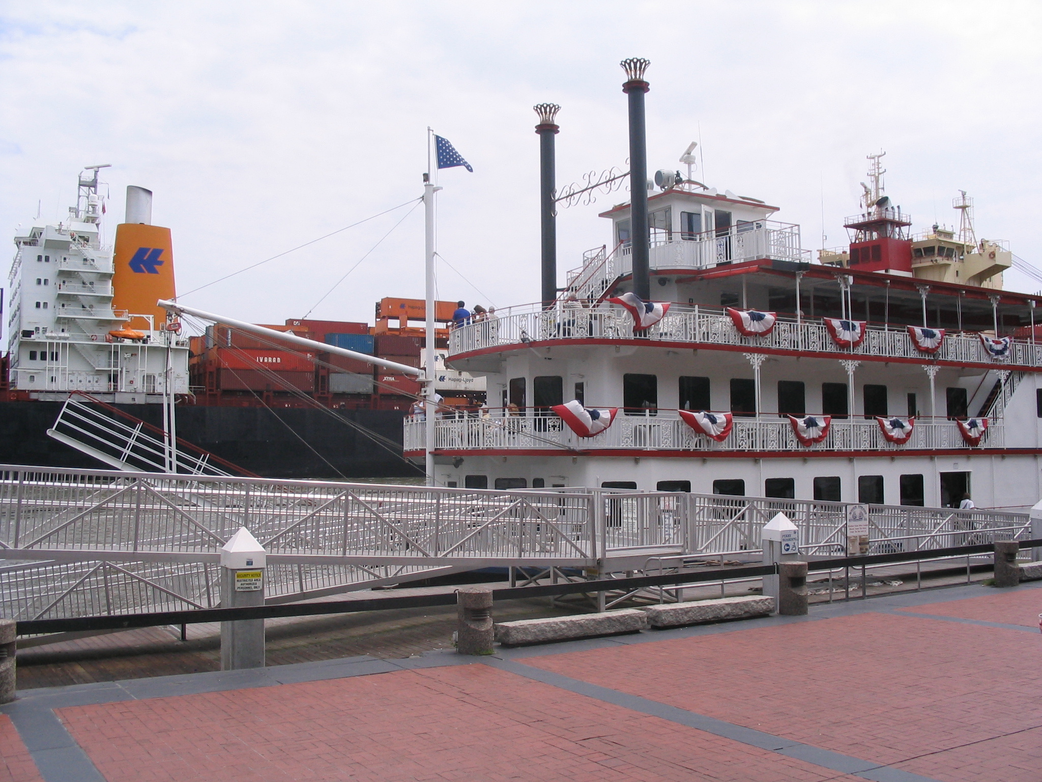 a large white ship sitting next to a red brick walkway