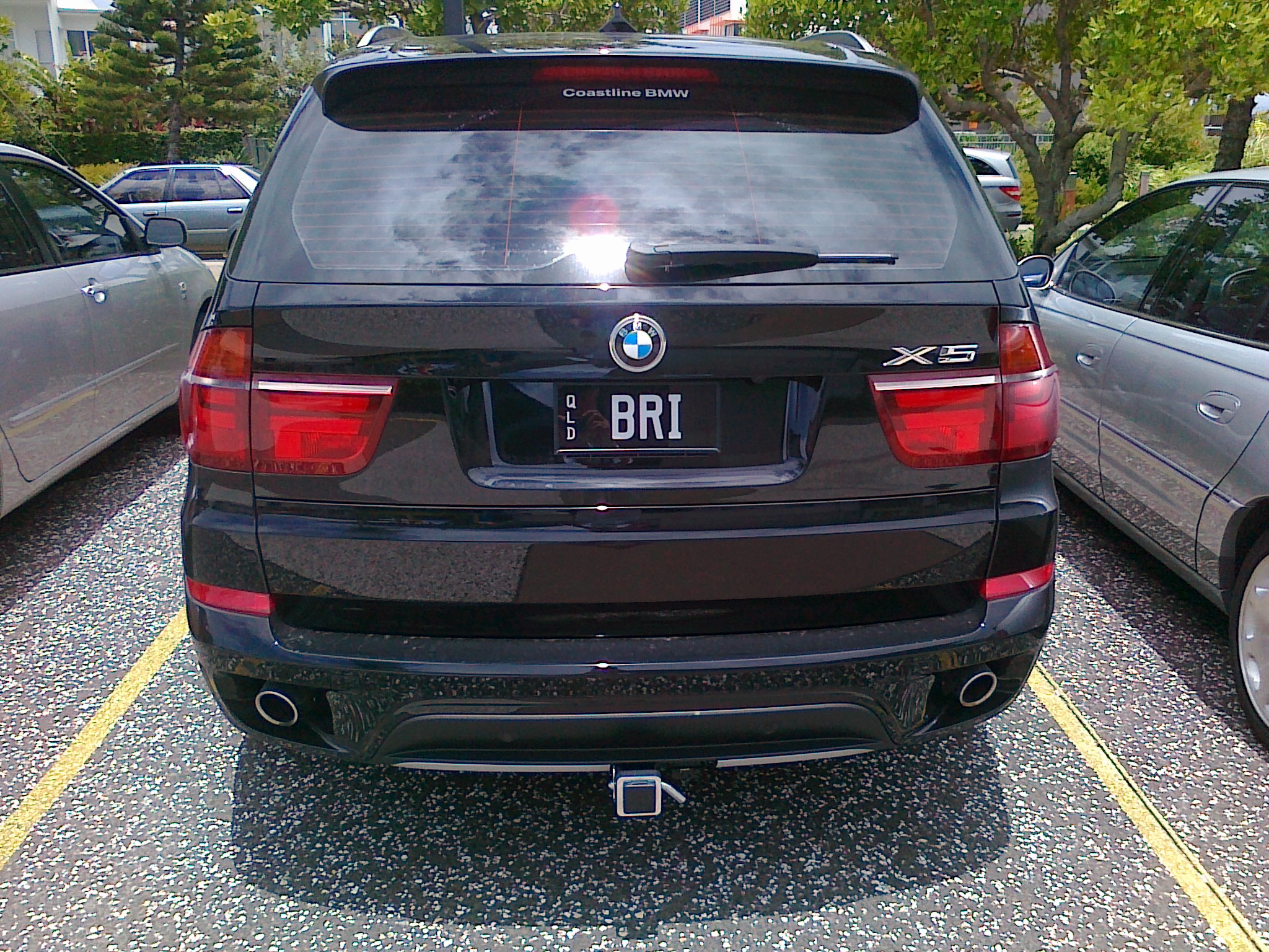 a black bmw is parked in an empty lot