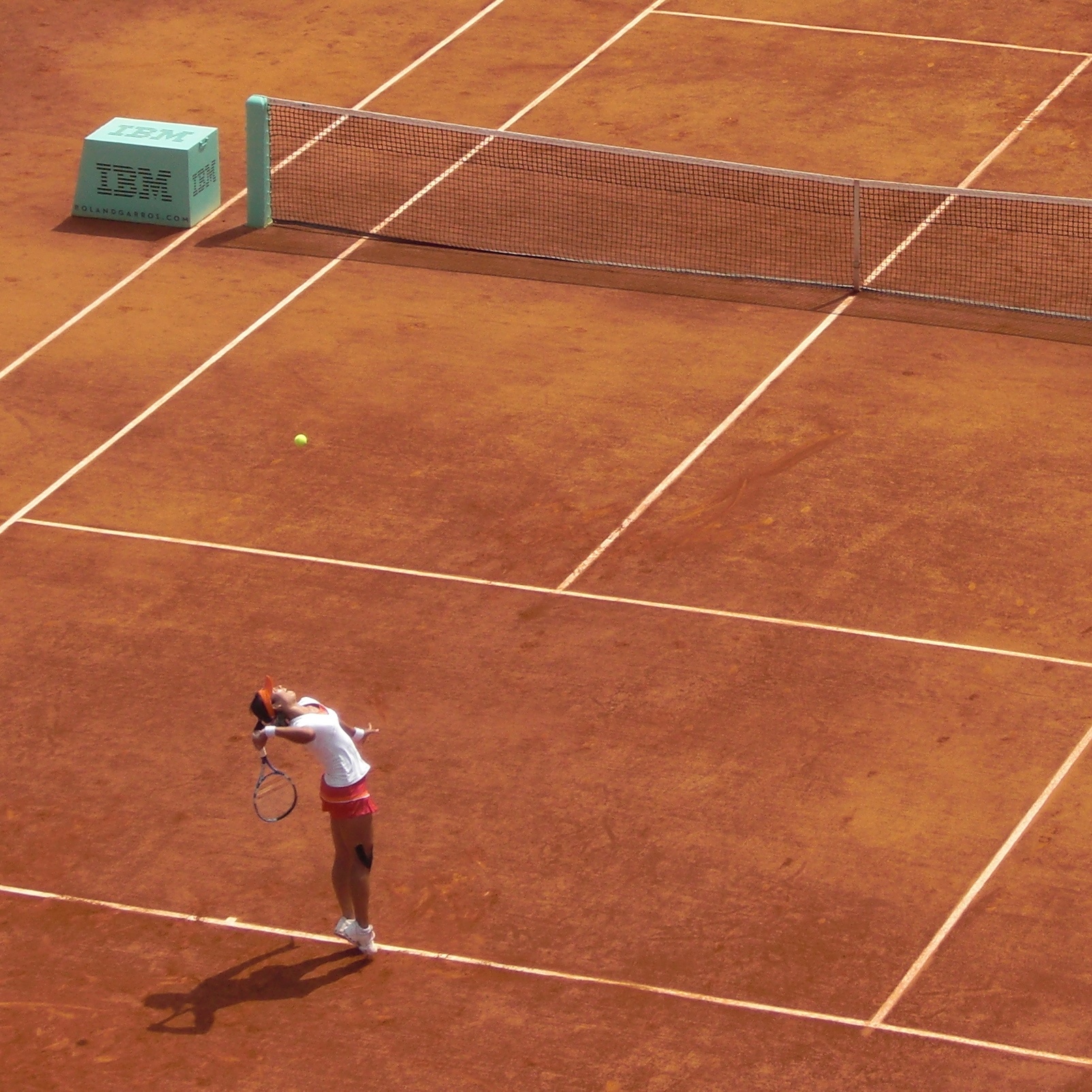 a person in red shorts and white shirt playing a game of tennis
