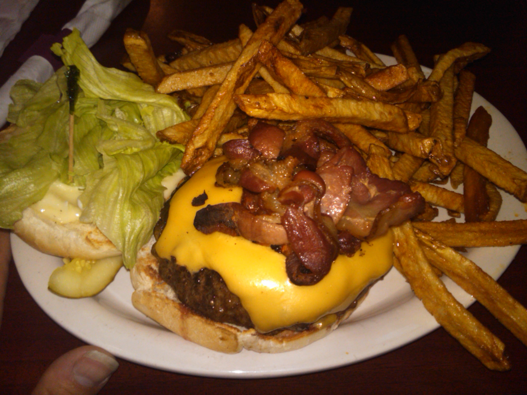 a plate with french fries, ketchup, and cheese burger