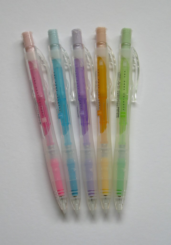 three different colored pens are lined up in an array