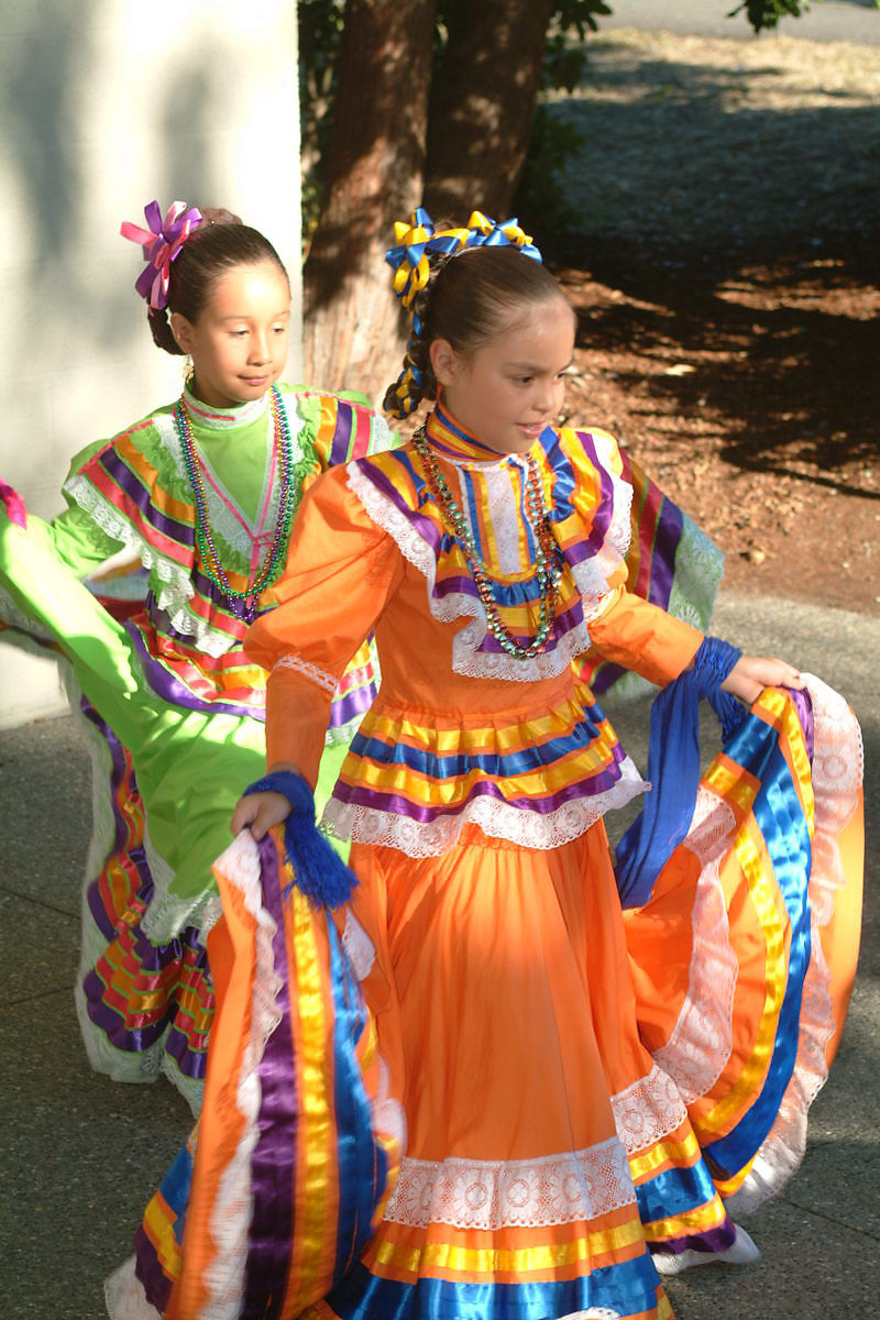 two girls are dressed in traditional costumes and clothing