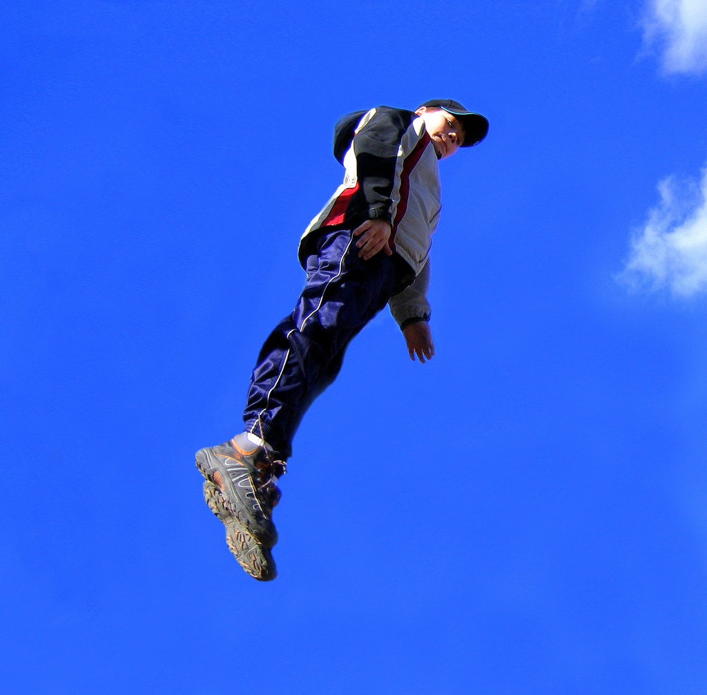 a man in mid air above the ground flying through the sky