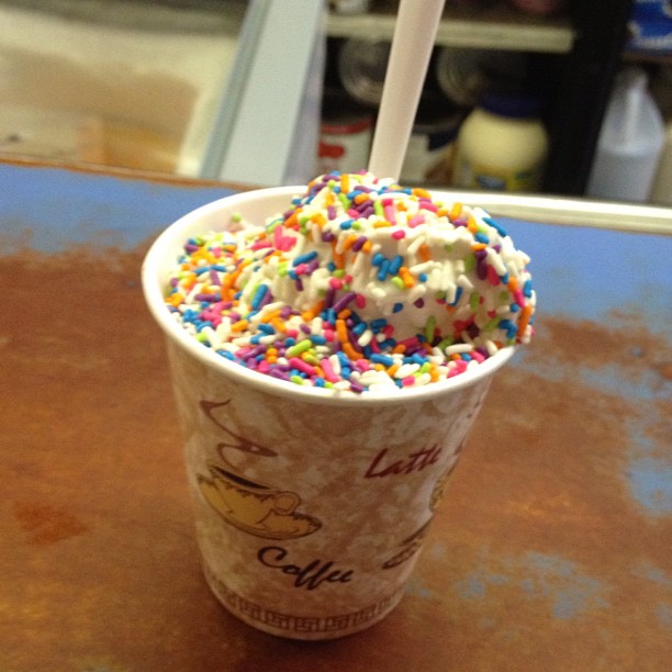 a cup with white chocolate and sprinkles in it