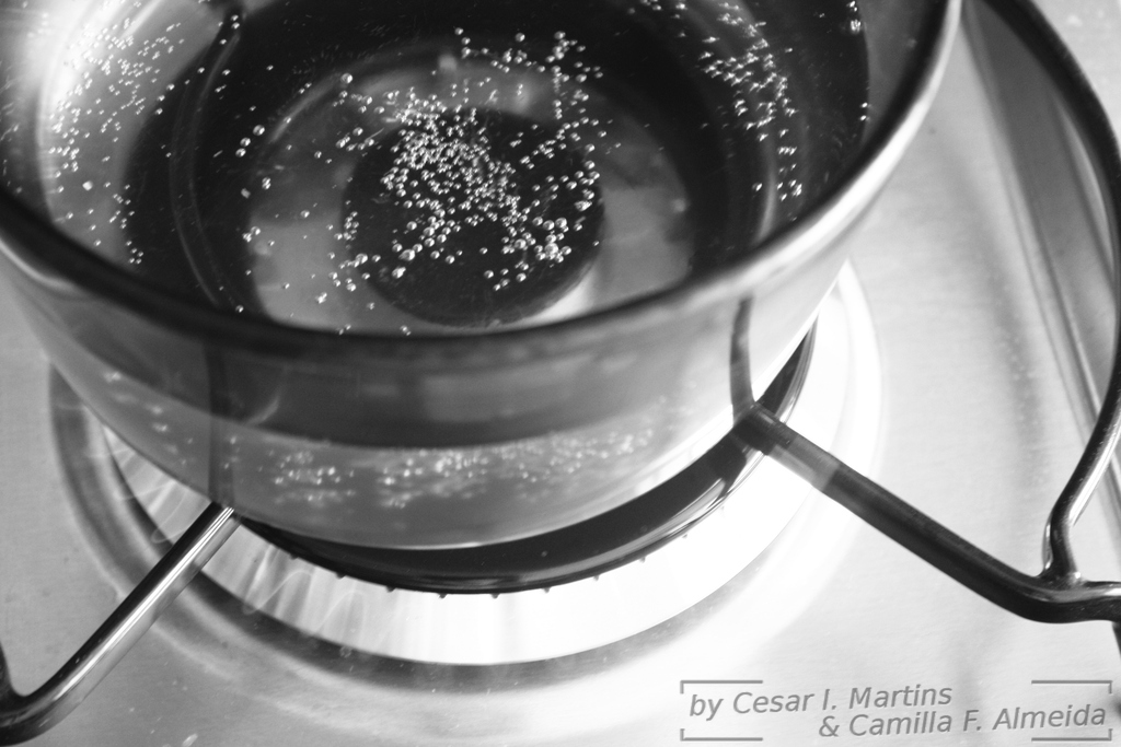 a bowl filled with liquid sitting on top of a stove