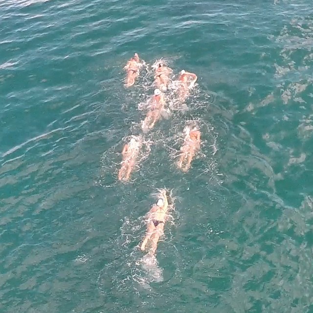 four people swimming in the ocean together