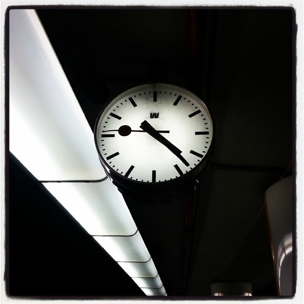 the clock is lit up on the ceiling