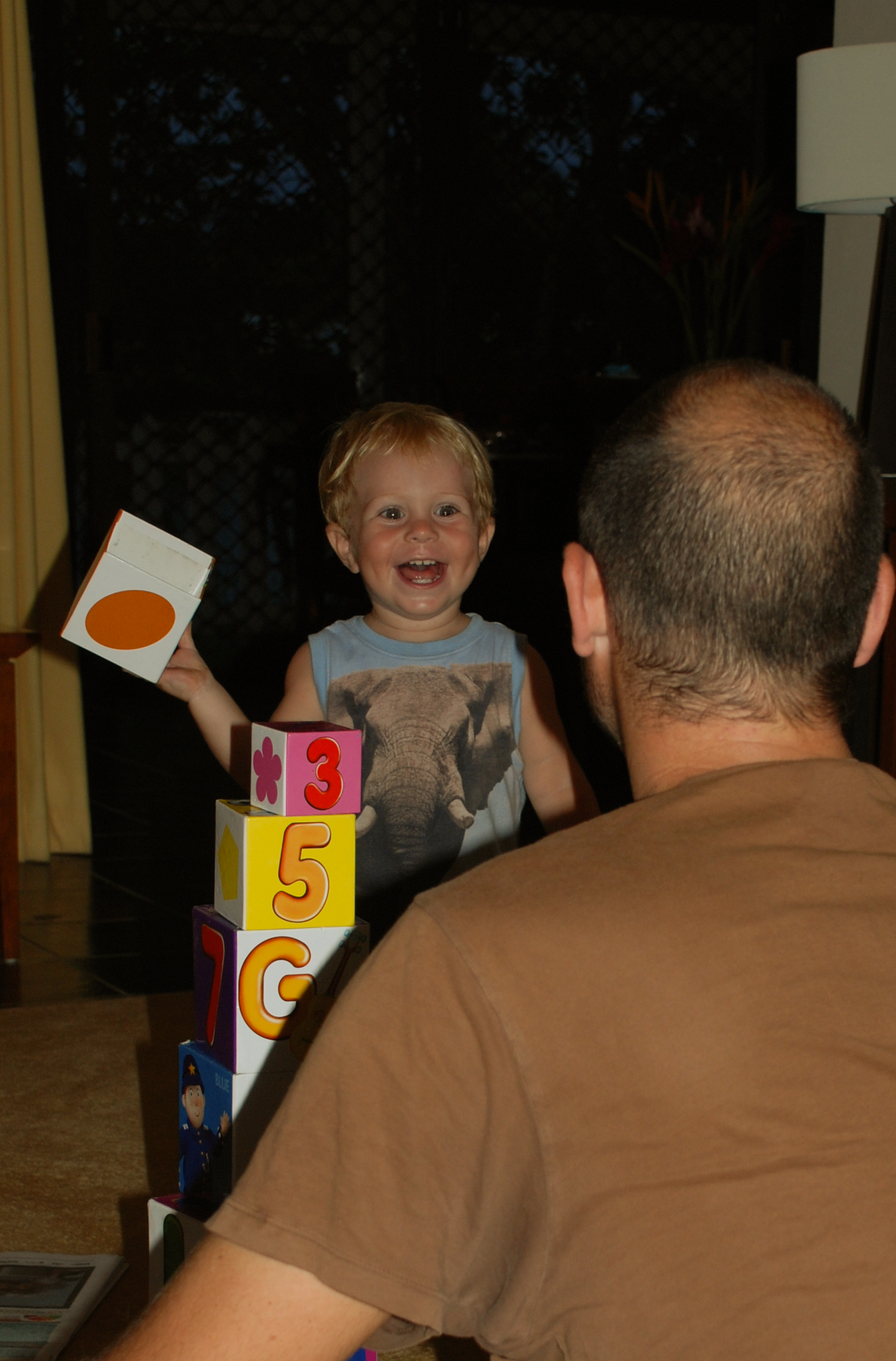 young man with blond haired boy playing with toy blocks