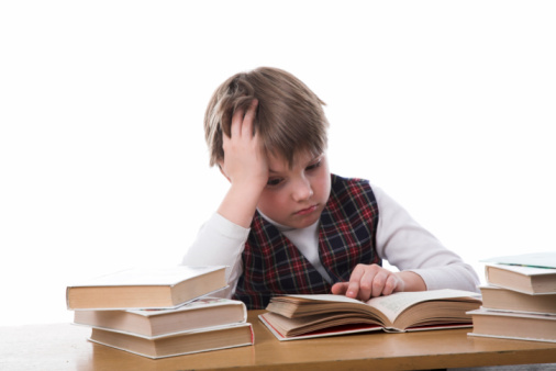 a boy is sitting at a table in front of several books