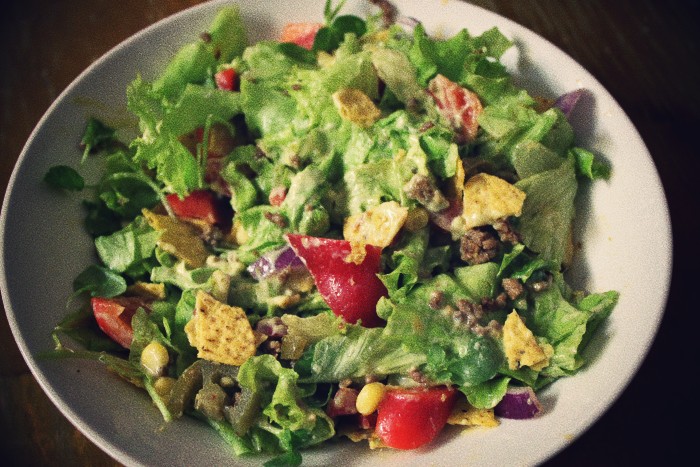 a bowl of food with a salad with dressing