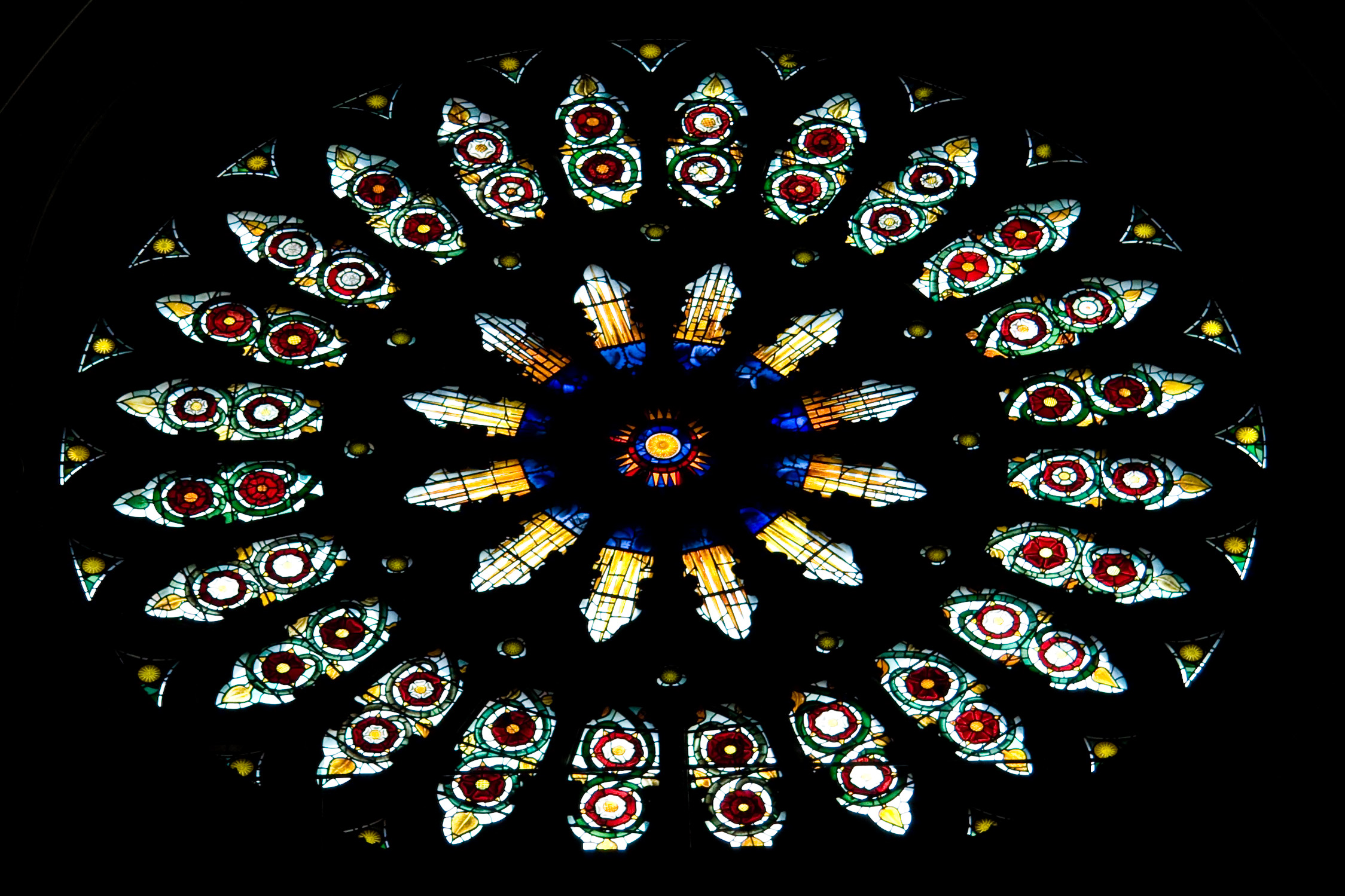 a very beautiful circular stain glass window in the front of a church