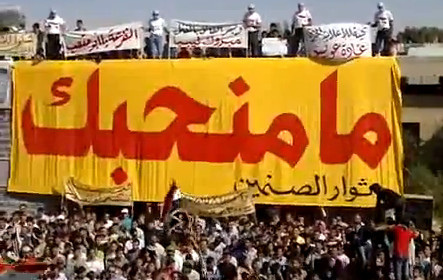several people are gathered on a yellow banner with large red and white letters