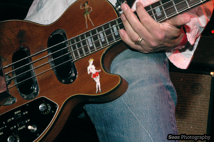 a man holding onto a brown and black bass guitar