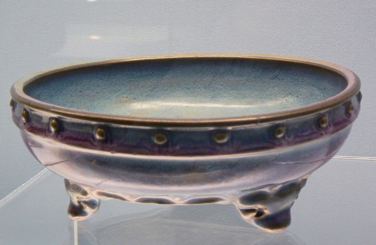 a blue and purple ceramic bowl sitting on a glass table