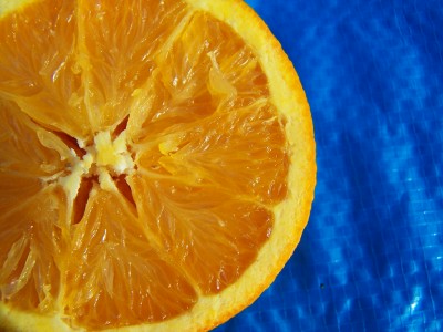 an orange sliced in half sitting on a blue surface