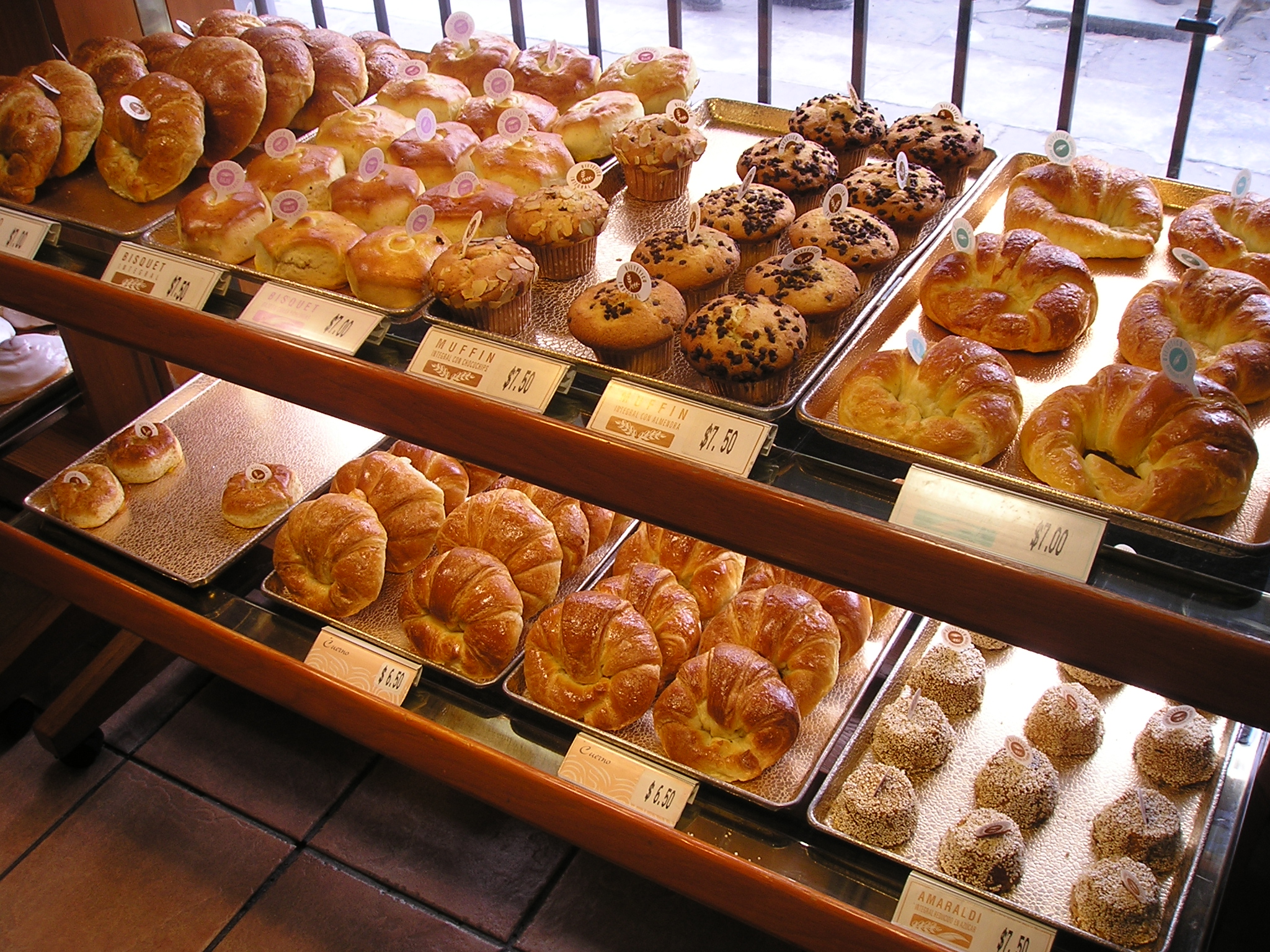 many types of pastries are on display on shelves