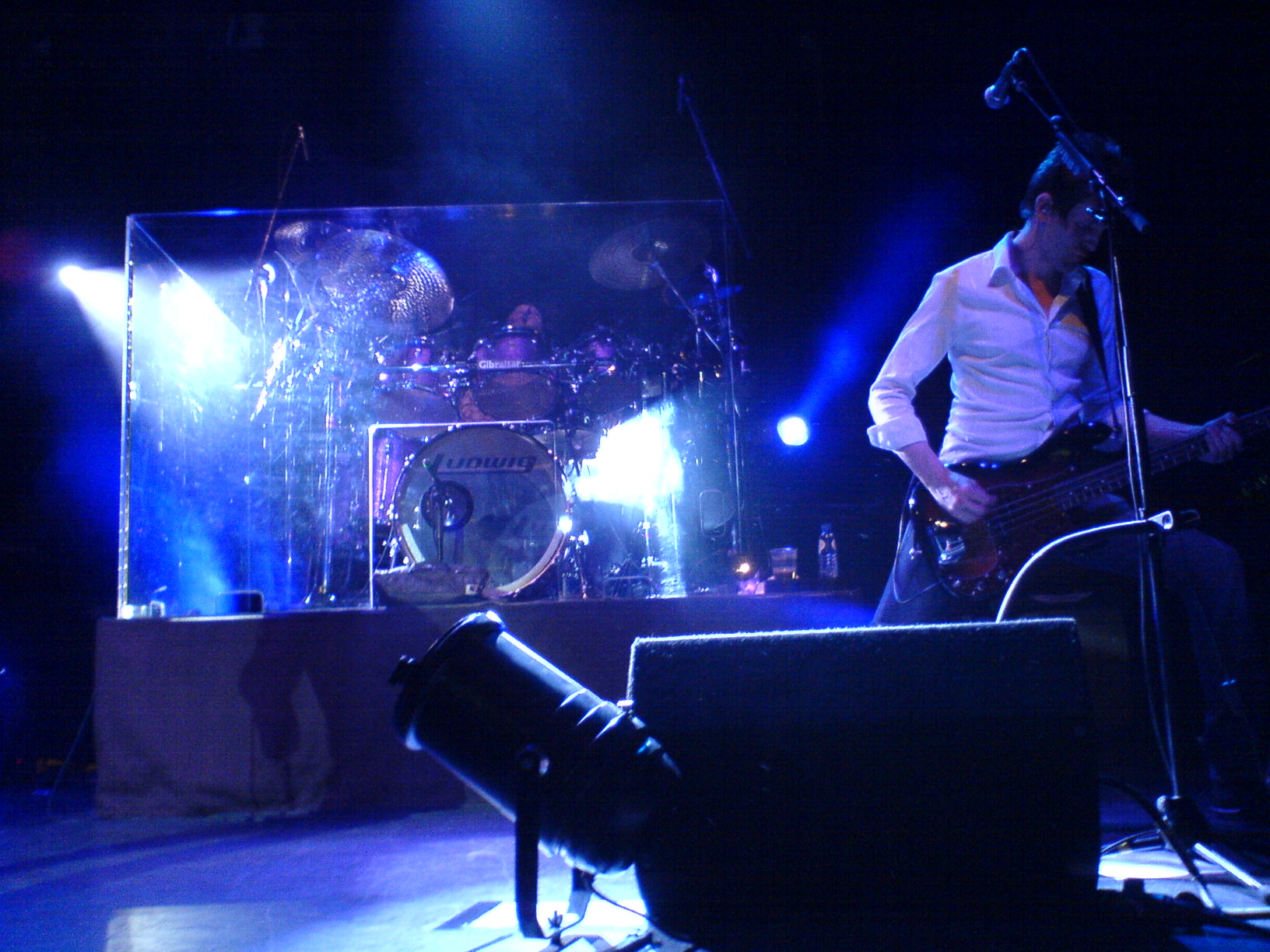 two people in front of microphones and drums