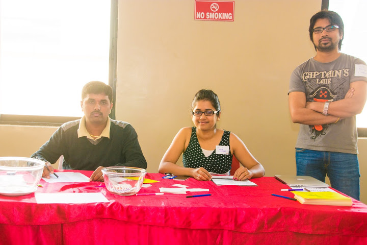 three people at a table with a red cloth