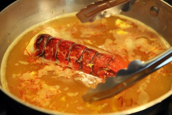 cooked lobster in a pot with tongs
