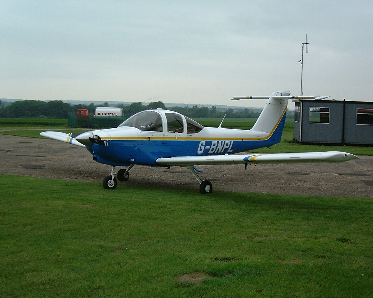 a small plane parked on a runway next to the grass