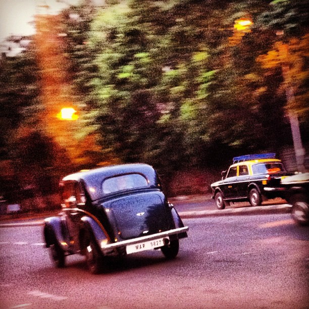 an old car going down the road in a vintage po