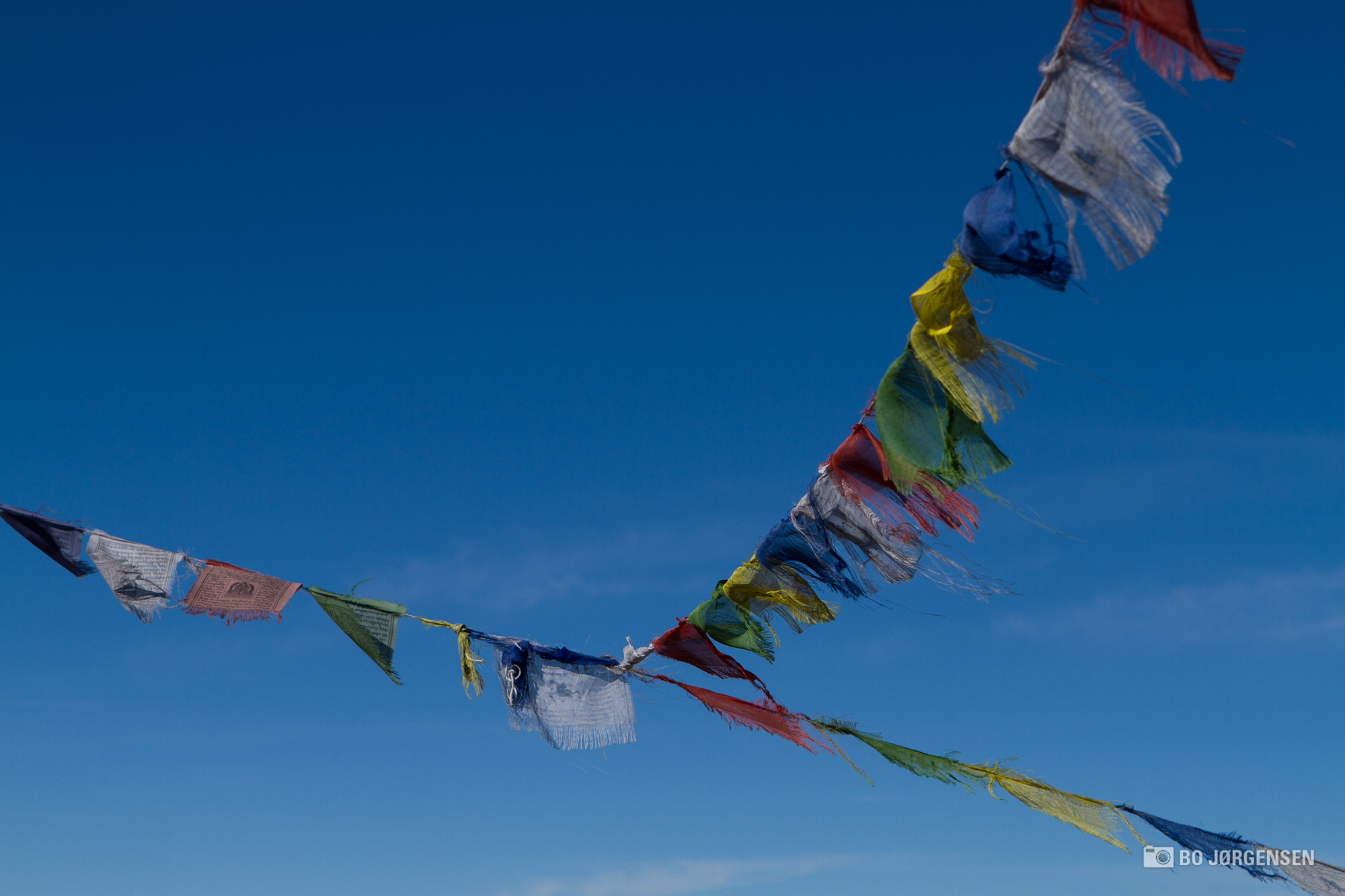 several kites flying in the blue sky on a sunny day