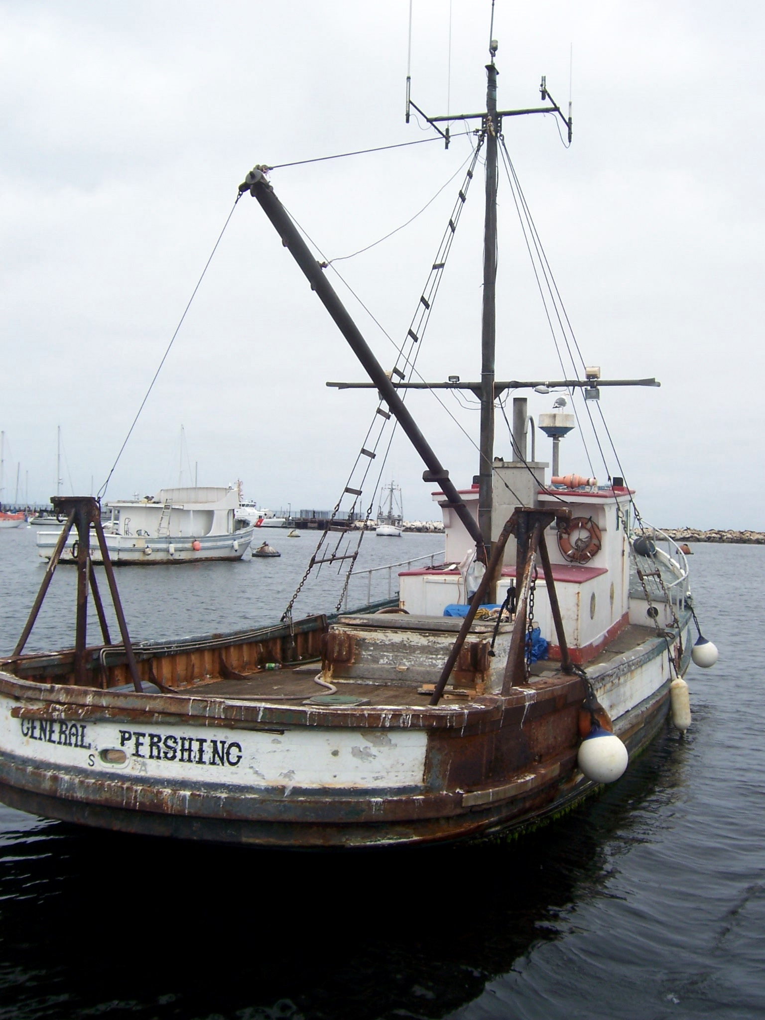 a fishing boat with a fishing pole sitting on the water