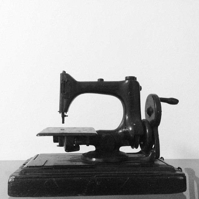 an antique sewing machine sitting on top of a wooden table