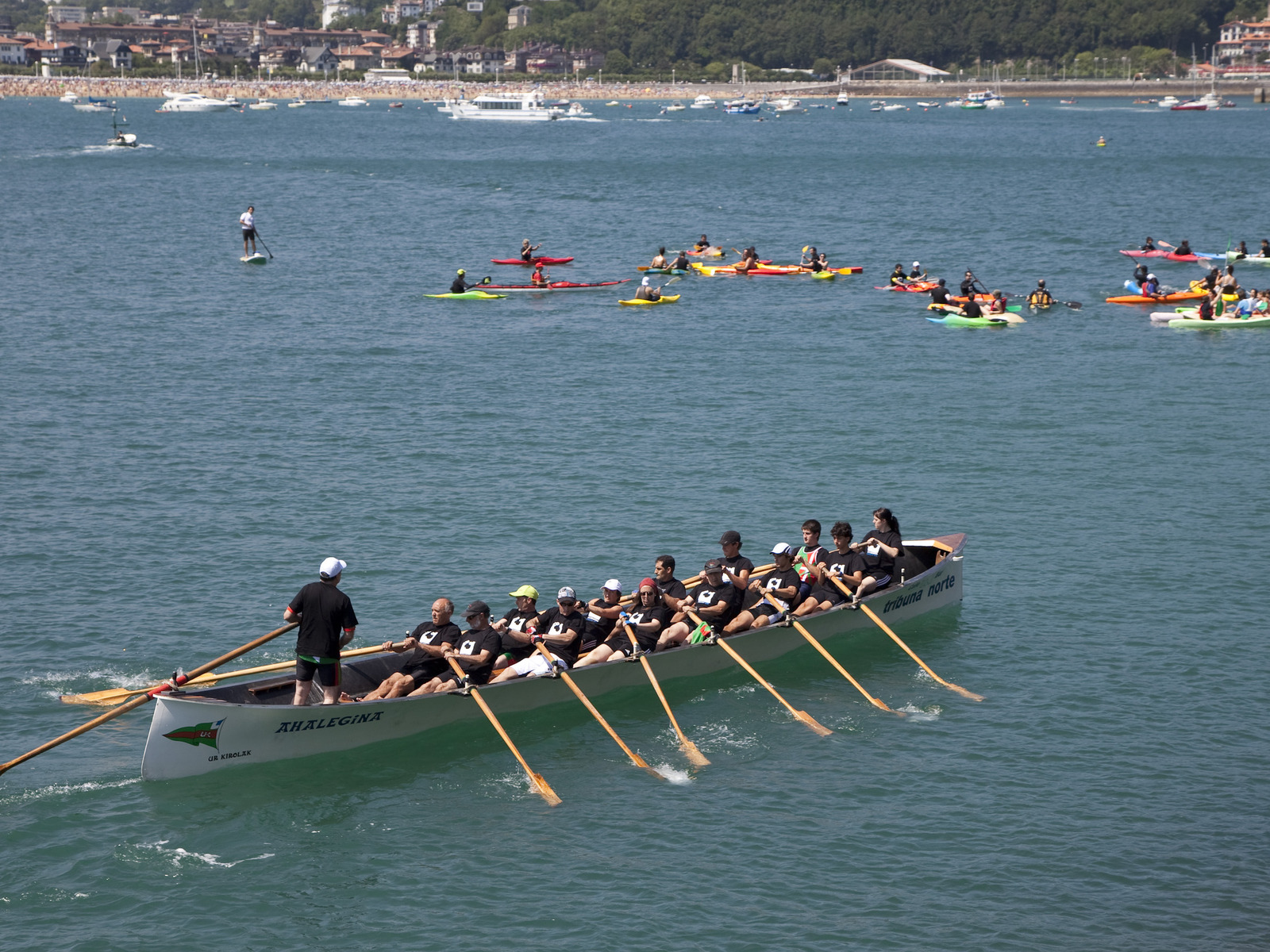 a boat full of people with long oars in the water