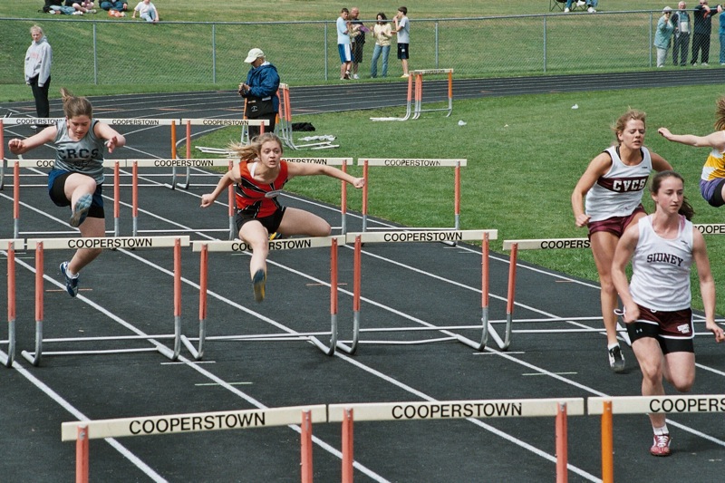 some s are running hurdles on an outdoor track