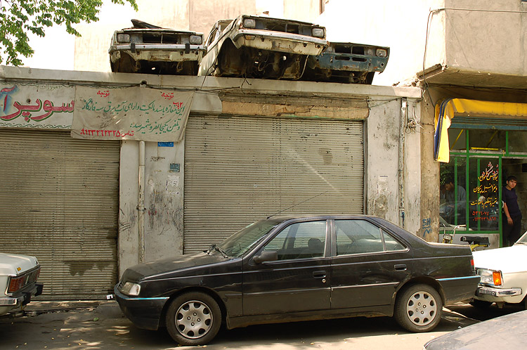 two cars parked in front of an abandoned business