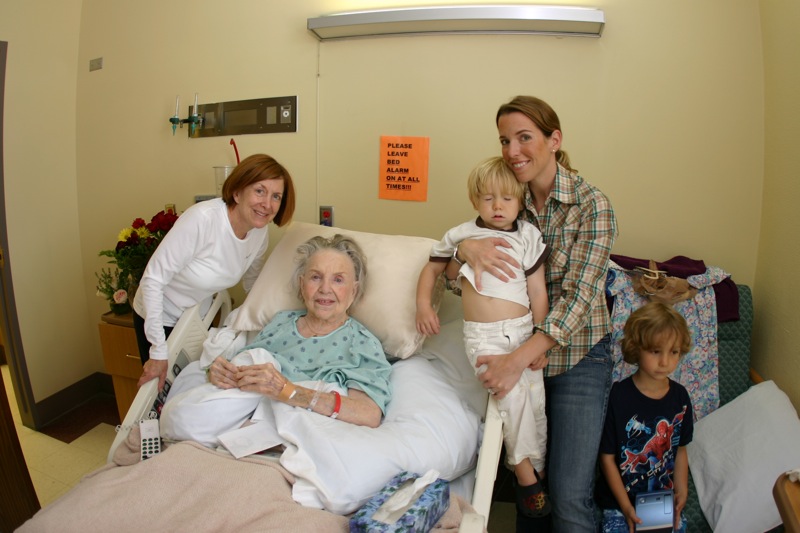 a woman and two children posing for a po in a hospital bed