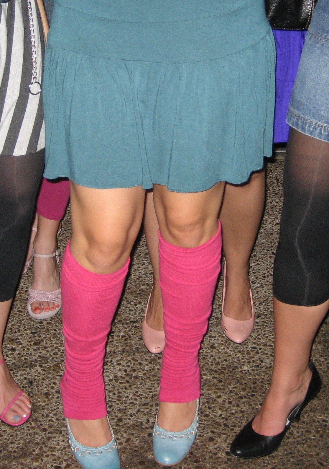 two women standing with pairs of pink socks