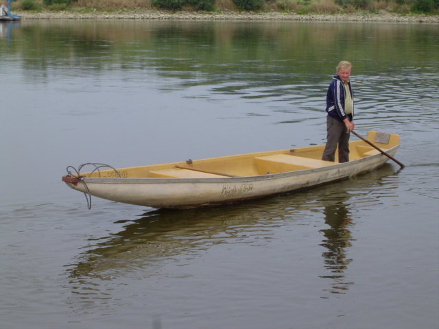 a man standing in a canoe with his oar in hand