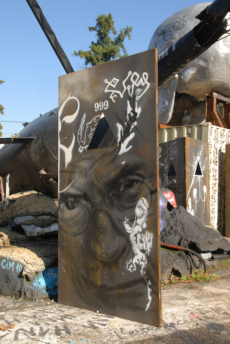 an old rusted sign on the street with graffiti