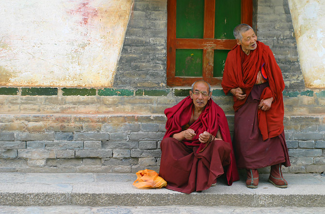 a couple of monks sit down on some steps